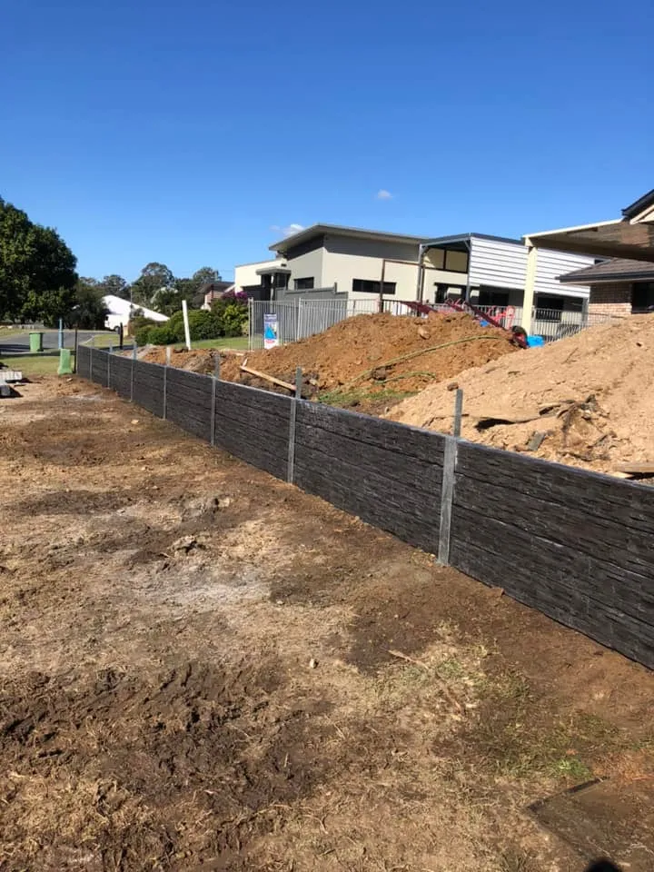 Long run of charcoal concrete sleeper retaining wall