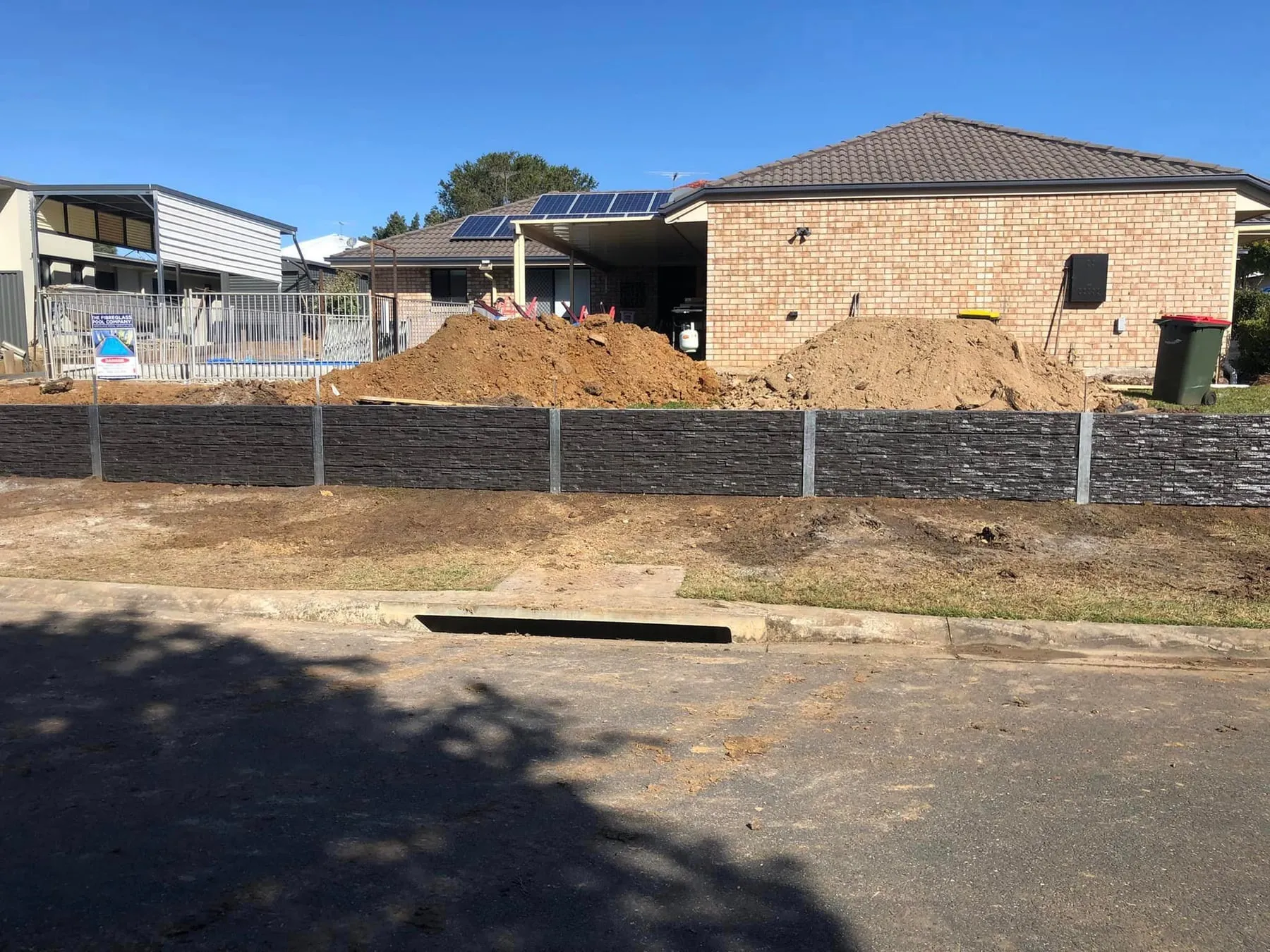 Charcoal concrete sleeper retaining wall at a new build